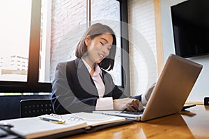 Closeup of businesswoman using laptop at office desk. She searching web or browsing information