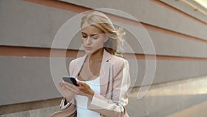 Closeup businesswoman using phone at street. Woman messaging on phone at street