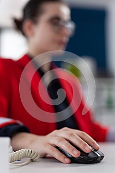 Closeup of businesswoman using wireless computer mouse in startup office