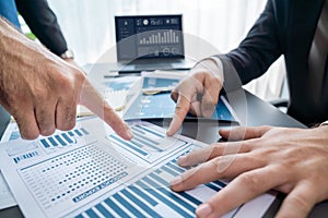 Closeup busy analyst team discussing financial data on laptop. Fervent