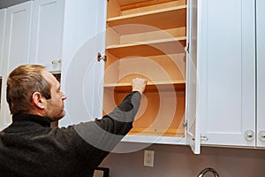 Closeup of a cabinet installer installing hardware on new kitchen cabinets.