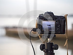 Closeup of a camera on a tripod outdoors. Background Landscape out of focus