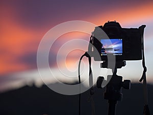 Closeup of a camera on a tripod outdoors. Background Landscape out of focus