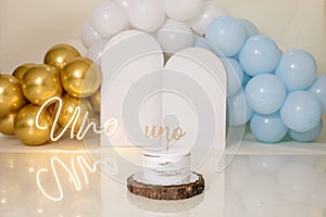 Closeup of a candle with an inscription against the background of colorful balloons.