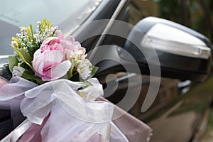 Closeup of a car decorated door with flowers at the wedding