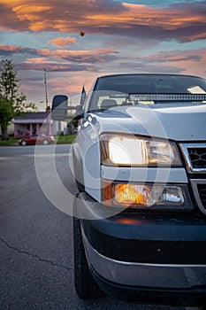 Closeup of a car headlights on the sunset