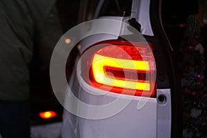 Closeup of car tail light on a white car.