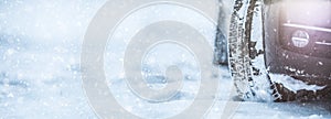 Closeup of car tyres on a snowy road. Snow on the road panoramic banner