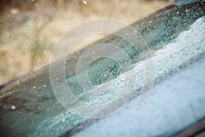 Closeup Car Wet Windshield and Windshield Wiper with Rain drop in Raining Season.