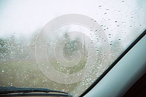 Closeup Car Wet Windshield and Windshield Wiper with Rain drop in Raining Season.