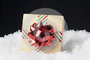 Closeup of cardboard gift box wrapped in striped ribbon and shin