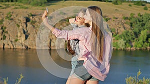 Closeup of carefree teen girls making funny faces and smiling for selfie.