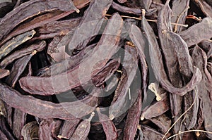 Closeup of carobs in a sack