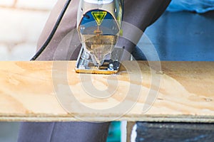 Closeup of Carpenter man using circular saw for cutting wood