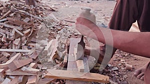Closeup of a carpenters hands using a chisel and hammer on wood at a construction site