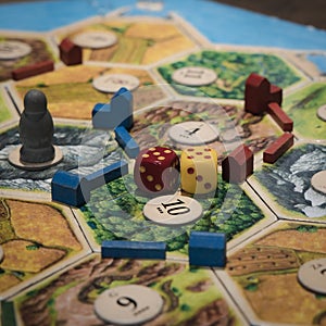 Closeup of a Catan board game with matching dice on it under the lights photo