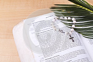 Closeup Catholic rosary with crucifix and beads on Holy Bible