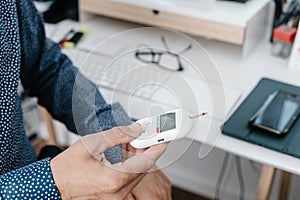 measuring his blood glucose level in the office photo