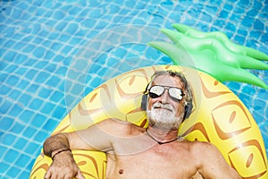 Closeup of caucasian senior man in the pool with headphones