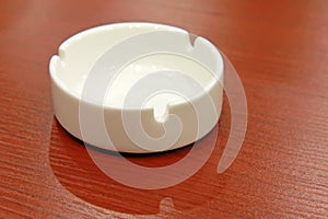 Ceramic ashtray on the red table