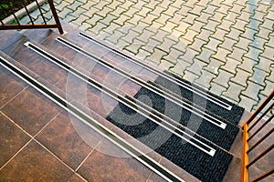 Closeup of ceramic tiles covering porch stairs with rubber anti slippery stripes on it
