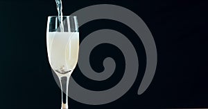 Closeup of champagne or sparkling wine being poured into a flute glass for a celebration or party event. Alcoholic