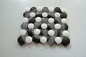 Closeup of check pattern made of black and white pills