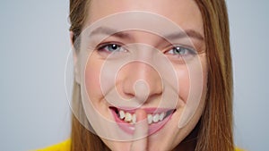 Closeup cheerful woman showing silence sign in studio camera on grey background.