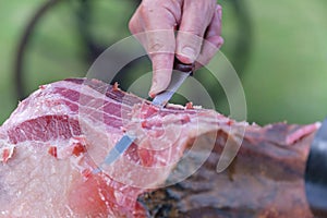 Closeup of a chef cutting raw Portuguese presunto with a knife