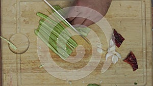 Closeup of the chefâ€™s hands slicing raw green pepper and smashes garlic