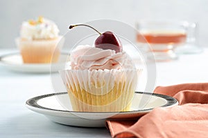 closeup cherry buttercream cupcake on plate