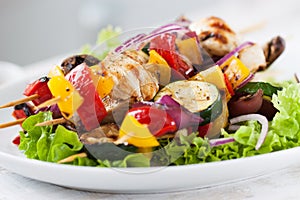 Closeup of chicken skewers or shashlik with grilled vegetables