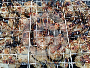 Closeup of Chicken wings and kebabs and on BBQ