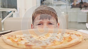 Closeup of a Child Eat Pizza. Little Hungry Boy Eating Tasty Italian Pizza From Plate. Unhealthy Nutrition Fast Food