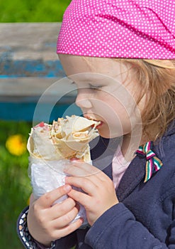 Closeup of a child eating fast food in the Park.