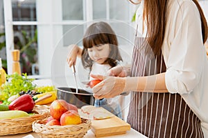 Closeup child girls playing innocently in the kitchen with mother cooking at home