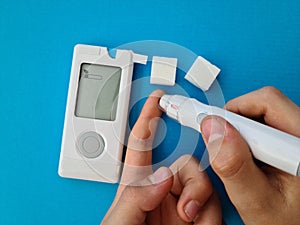 Closeup of child hand checking blood sugar levels with glucometer photo