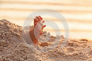 Closeup child kid feet on white sand beach.