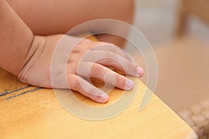 Closeup of a child's hand sitting on a desk,