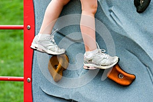 Closeup Child's Legs on Rock Wall