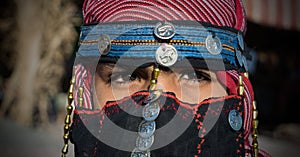 Closeup of a child in a veil with sewed coins