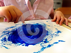 Closeup of children hands painting during a school activity - ice painting - learning by doing, education and art, art therapy