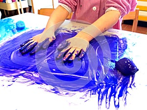Closeup of children hands painting during a school activity - ice painting - learning by doing, education and art, art therapy