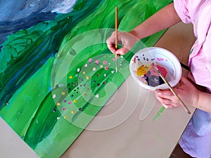 Closeup of children hands painting during a school activity - learning by doing, education and art, art therapy concept