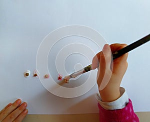 Closeup of children hands painting during a school activity - learning by doing, education and art, art therapy concept