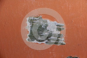 closeup of chipped paint on red wall