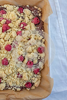 Closeup of chocolate cake with raspberry and streusel