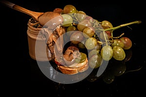 closeup chocolate peanut butter in glass jar with green grapes