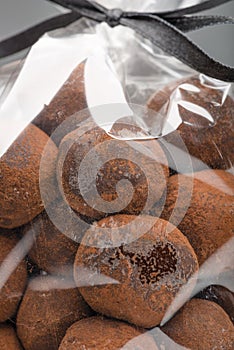 Closeup on chocolate truffles in luxury plastic bag with ribbon