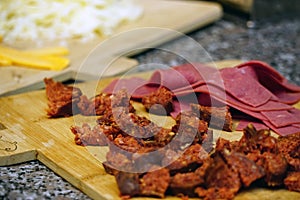 Closeup of chopped sausage and jambon on cutting board